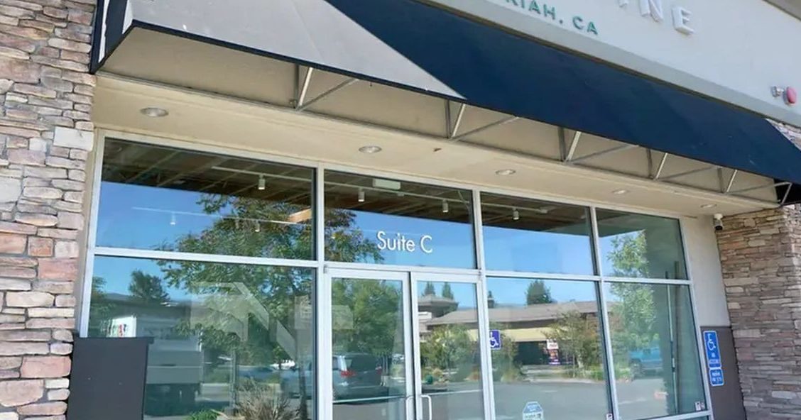 Exterior de la tienda Cannavine Ukiah con puertas de vidrio y pilares de piedra