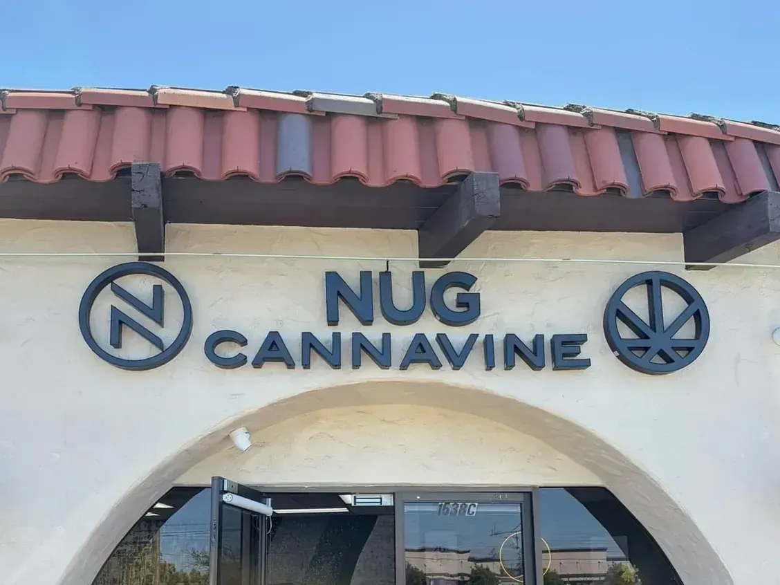 Nug Cannavine storefront with tiled roof, arched entrance, and blue signage
